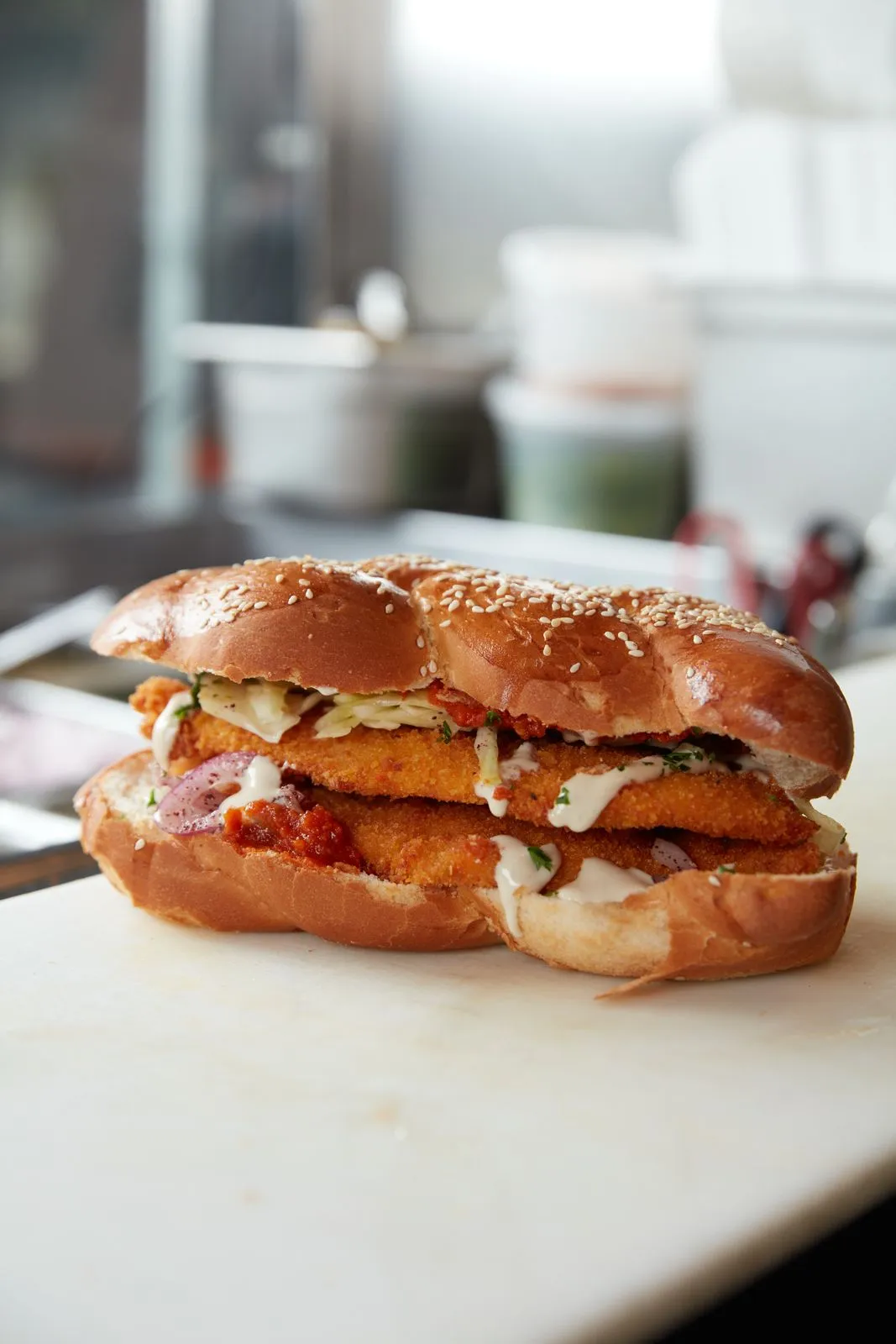 Hummus Bodega Challah Schnitzel — crispy chicken schnitzel sandwiched in fresh challah with matbucha and red cabbage, available only on Fridays at our Berkeley location.